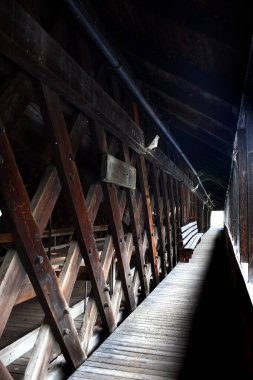 Örümcek ağları, New Hampshire 'daki Haverhill-Bath Kapalı Köprüsü' nün yayanın içinden sarkıyor. Bankta tünelin sonuna doğru oturuyor..