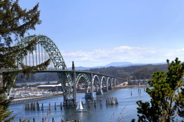 Oregon, Newport yakınlarındaki Yaquina Körfezi Köprüsü 'nde beyaz yelkenli kayıyor..