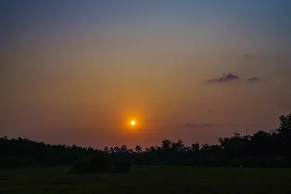 The sun, which is like a little egg yolk, is about to set, following the atmosphere of the rice fields in the evening.