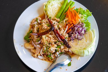 Tayland yemeklerine larb denir. Kıyılmış domuz eti, yeşil yapraklı sebzeler ve kurutulmuş biberlerden oluşur. Kepçelemek ve yemek için kaşık ile bir tabağa konur..