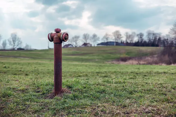 stock image Rusty fire hydrant in a field with green grass