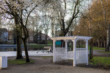 Gölün yanındaki şehir bahar parkında beyaz salıncak. Yüksek kalite fotoğraf