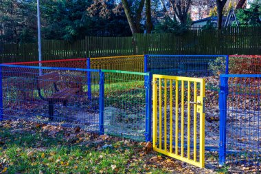 Parlak renkli çitlerle çevrili boş bir çocuk kum havuzu. Kapıyı açın. Yüksek kalite fotoğraf