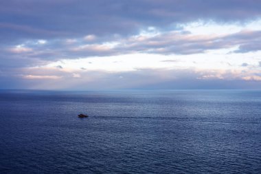 Gün batımında Atlantik Okyanusu 'nun dalgalarında yüzen küçük bir tekne. Topraksız bir okyanus. Okyanustaki ufuk çizgisi. Yüksek kalite fotoğraf