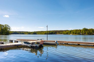 Gölün kıyısındaki birkaç tekne için küçük ahşap bir iskele. Tekneler ahşap bir iskeleye bağlı. Yüksek kalite fotoğraf