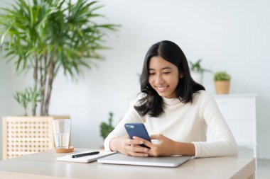 Asian woman using smartphone in morning at home, Asia girl text mobile phone happy smile on young face