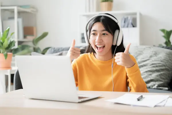 在家学习 亚洲女孩在网上通过网络学习视频会议 电脑辅导 亚洲妇女在家里早上使用带耳机的笔记本电脑 免版税图库照片