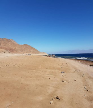 Kumlu genişlikleri ve görkemli kayalık dağlarıyla Mısır 'ın etkileyici manzarası. Güneş ışınları kum ve kayalık yamaçların dokusunu vurgular. Seyahat kavramları, tarihi temalar veya çöl estetiği için