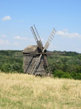 Yeşil bir çayırın ortasında eski bir ahşap değirmen kaybolmuş. Tarihi cazibe ve rahat kırsal alan. Gelenek, nostalji, eko-turizm veya peri masalı çizimleri kavramları için.