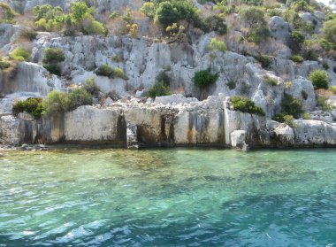 Resimli şehir deniz kıyısına yayılmış durumda. Güneş ışınları dalgalara yansıyarak büyülü bir huzur ve rahatlama atmosferi yaratıyor. Turistler, şehir konforu ve deniz aşkı için.