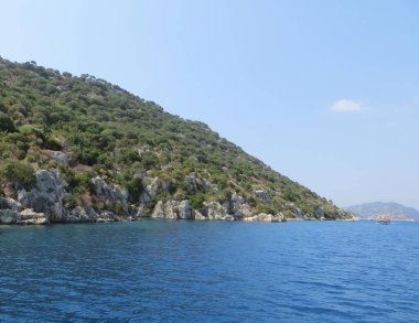 Resimli şehir deniz kıyısına yayılmış durumda. Güneş ışınları dalgalara yansıyarak büyülü bir huzur ve rahatlama atmosferi yaratıyor. Turistler, şehir konforu ve deniz aşkı için.