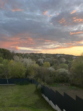 Sihirli bir günbatımı gökyüzü, pembe, turuncu ve altının sıcak gölgeleri. Yumuşak ışık bir barış ve uyum ortamı yaratır. Günün sonunu, romantizmi ve şafağın güzelliğini simgeler..