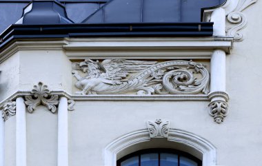 Bu tarihi binanın dış cephesinde bazı karakterleri, hayvanları ya da çiçekleri temsil eden renk detaylarıyla çekildi. Riga, Letonya, Avrupa 'da geçiyor.