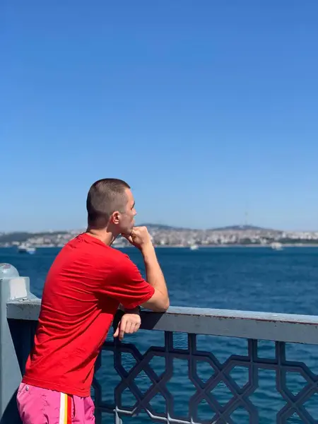 Bir adam denize doğru bakar.