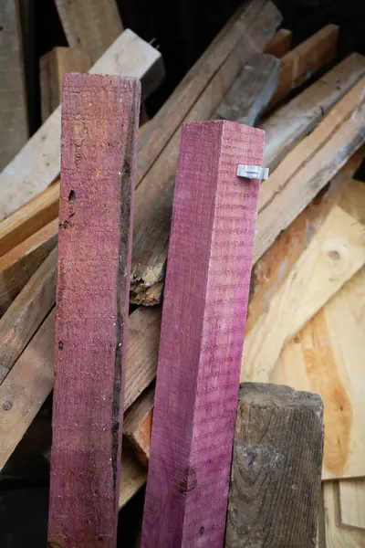Mor lekeli iki ahşap tahta parçasının yakın plan çekimi doğal, lekesiz ahşap parçaların üzerinde duruyor. Karşıtlık, çeşitli marangozluk projeleri için dokuyu ve potansiyeli vurguluyor.