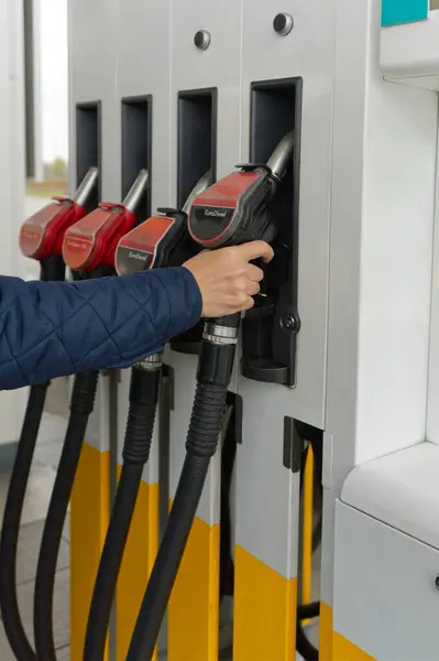 Bir kişi, EuroDiesel hortumunu seçerek bir benzin istasyonunda aracına yakıt ikmali yapıyor. Olay yerinde yakıt ikmali eylemi ve yakıt türünün seçimi vurgulanarak çeşitli yakıt seçenekleri sergileniyor.