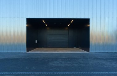 Oluklu metal duvarlı boş depo girişi, iyi aydınlatılmış, yeni inşa edilmiş, ferah, işlevsel, modern, endüstriyel tasarım, depolama ve lojistik için pratik.
