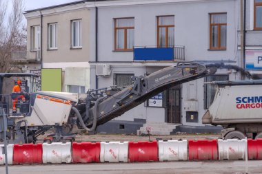  Polonya Ostrowiec Swietokrzyski 14 Mart 2024 saat 12: 17 'de bir yol inşaatındaki eski asfaltı parçaladı. Güçlü bir makine, bir WIRTGEN değirmen makinesi, yolun yeniden inşası sırasında asfaltı parçalıyor..