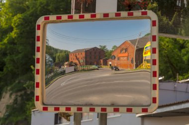 View on old town of poland.Old historic brick mill reflected in the mirror sign (u-18b). Monuments of mill architecture. An old red-brick mill reflected in the road mirror .   clipart