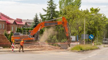  Makineli bir inşaat işçisi. Polonya Ostrowiec Swietokrzyski 6 Haziran 2023 saat 10: 52. Yıkım sırasında Doosan DX 340LC kazıcı. Bahar başında bir yolun yapımını engelleyen bir binanın yıkılması sırasında büyük bir sürüngen kazıcı.
