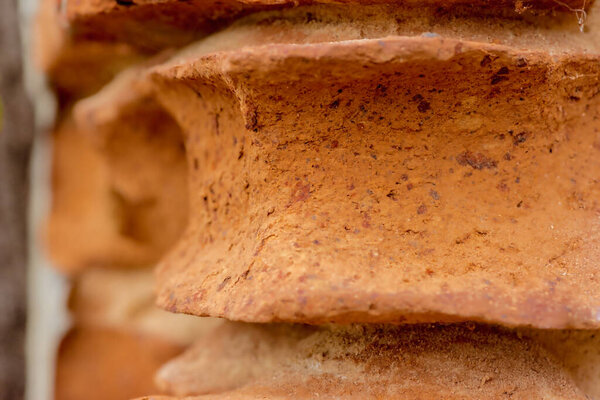"Stack of bread slices on wooden table". A wall made of old, heavily eroded red bricks. A heavily damaged brick wall made of bricks with extremely strange shapes given by time - and rain, wind, frost, etc.. ) ....  