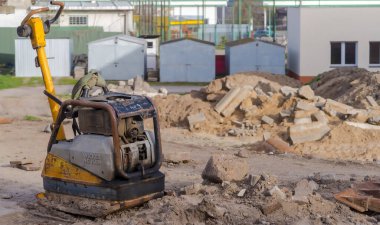 30 Mart 2024 saat 17: 24 'te Polonya Ostrowiec Swietokrzyski. Wicker NEUSON sıkıştırıcısı. Yol inşaatı. Kazılmış toprak, moloz ve eski tuğlalar arasında plaka sıkıştırıcısı.  