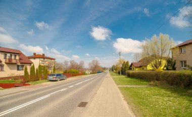 View of the street of old town of Szewna, of Poland.Spring in the hills near Ostrowiec  under a blue sky. A road running through the neighboring town just before Ostrowiec. Beautiful sky with delicate clouds .  clipart