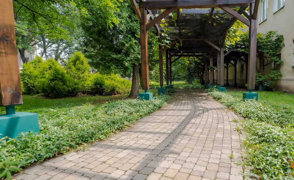 Красивый парк в городе. Беседка - беседка в парке. Прогулка среди обилия летней растительности. Парк крошечные аллеи - вымощенные и проходящие через красиво посаженные растения среди садовой архитектуры.  