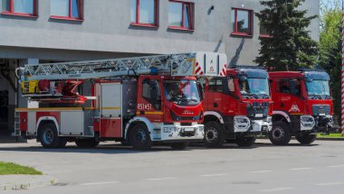 Poland Ostrowiec Swietokrzyski April 29, 2024 at 1:47 p.m. Combat fire trucks standing in front of the fire station. Red fire trucks (of various brands), washed and clean, stand shiny in the square in front of the fire station.   clipart