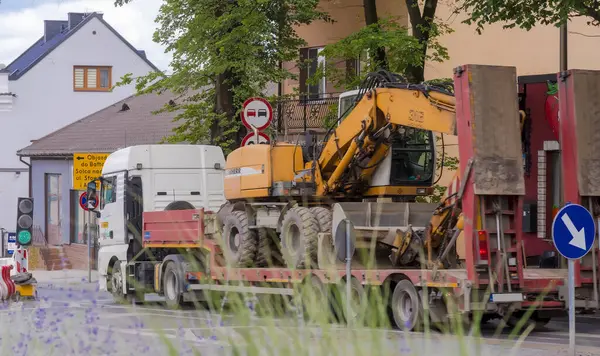 stock image Poland Ostrowiec Swietokrzyski July 2, 2024 at 14:49.A Liebherr excavator transported on a large trailer .A German wheeled excavator transported on a semi - trailer pulled by a powerful tractor-trailer heading to a road construction site in the city.