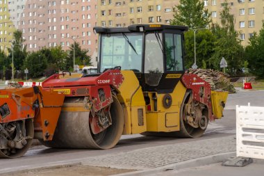 İnşaat alanında yol silindiri. Polonya Ostrowiec Swietokrzyski 8 Temmuz 2017: 59 Dynapac yol silindiri. Şehir merkezinde bir yaz öğleden sonra yeni bir yolun yüzeyinde duran yol yapım makineleri. 