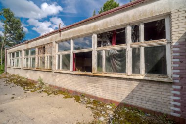 Yazın gökyüzünün altında, ormanın ortasında terk edilmiş ve harap olmuş eski bir endüstriyel bina. Terk edilmiş, unutulmuş ve yok edilmiş bir sanayi binası - şehir keşfi aşıkları için gerçek bir ziyafet (urbex).