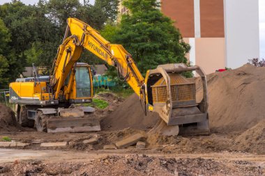 Polonya Ostrowiec Swietokrzyski 25 Temmuz 2024: 24. HYUNDAI kazıcısına monte edilmiş döner bir aletle topraklama. Güçlü bir Koreli kazıcı, hidrolik olarak kazıcı sisteminden güç alan dönen bir 