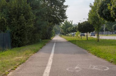  Asfalt bisiklet yolu ve şehrin zengin doğal alanlarından geçen dar kaldırımlar. Asfalt bisiklet yolunda, amacını gösteren bir bisiklet piktogramı, yanında, asfalta boyanmış beyaz bir çizgi, dar bir kaldırım. 