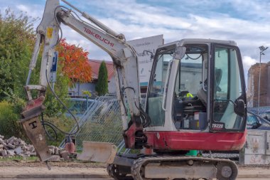  Polonya Ostrowiec Swietokrzyski 11 Ekim, 2024 1: 05 Bir yol inşaatı alanında TAKEUSCHI sürüngen kazıcı ile. Çalışan kolunun ucunda hidrolik yıkım çekici olan küçük bir Japon sürüngen kazıcısı. .