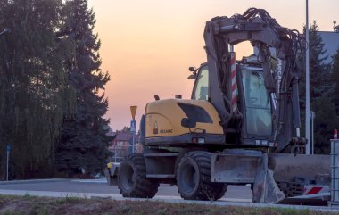  Polonya Ostrowiec Swietokrzyski 19 Eylül 2024, 17.59 MECALAC kazı alanı, gün batımından sonra yeni inşa edilen bir yol üzerinde. Yaz bitmeden üç gün önce gün batımından hemen sonra çok yönlü bir kazı alanı.. 