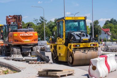 Yeni bir yolun şantiyesinde ağır makineler var. Polonya Ostrowiec Swietokrzyski 31 Temmuz 2024: 54. HITACHI kazıcı yol silindirleri BOMAG ve HAMM. Son çalışmalardan hemen önce yeni bir yolun yüzeyinde duran yol yapım makineleri. 