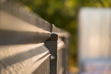  Çit bahçede. Çelik çitlerden yapılmış bir çit için bir direk. Bir sonbahar sabahı güneş ışığında resim gibi görünen bir çit..