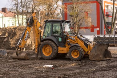 Yeni bir binanın inşaatı. Polonya Ostrowiec Swietokrzyski 21 Aralık 2024, saat 12: 28. CASE 5980ST - inşaat alanında kepçe yükleyici. Şehirdeki bir şantiyede güneşli, açık bir gün. 