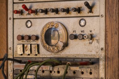 Beyaz arka planı olan paslı bir elektrik paneli. Tarihi santral - antika analog telefon santrali. Şalter ve düğmelerle dolu eski moda bir telefon santrali.. 