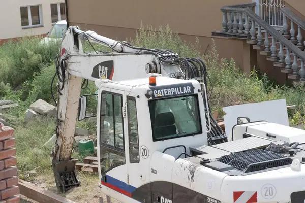 Polonya Ostrowiec Swietokrzyski Ağustos 1 2024 11: 18 Bir beyaz tırtıl kazıcısı tuğla bir binanın yıkımına karıştı Kazıcı siyah ve beyaz renkli bir şemaya sahip ve kolunda görünür hidrolik bileşenler ile donatılmıştır