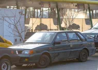 Polonya Ostrowiec Swietokrzyski 7 Şubat 2025: 12. POLONEZ ATU yeşil renkli Polonya yapımı sedan, diğer araçların yanına park edilmiştir. Sedan, yüzeyinde görünür toprak bulunan 20. yüzyıl sonlarındaki modellere özgü bir kutu tasarımı içerir.. 