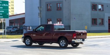 Polonya Ostrowiec Swietokrzyski 20 Mart, 2025: 16 Burgundy DODGE RAM 1500 Amerikan kamyoneti Polonya caddesi kullanıyor. Araç, taksisi ve krom tekerlekleri olan tipik Amerikan kamyonlarının büyük ve sağlam yapımıyla dikkat çekicidir. Hareket ediyor.