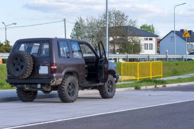 Polonya Ostrowiec Swietokrzyski 20 Nisan 2025: 04. Bir bahar günü otoparkta OPEL Monterey 'in aşırı off-road' u. Araç koyu renkli, geniş off-road lastikleri ve yedek lastiği var. Şoförün kapısı açık..