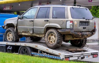 Polonya Ostrowiec Swietokrzyski 15 Mayıs 2025: 38. Görünürde hasarlı ve çamurlu bir off-road rallisinden sonra bir çekiciyle JEEP GRAND CHEROKEE. Çürük bir vücut ve pas bantları ile aşınma belirtileri gösteriyor, muhtemelen off-road aktivitesinden.. 