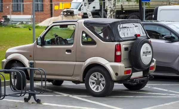 Polonya Ostrowiec Swietokrzyski 19 Mayıs, 2025: 54 PM. SUZUKI JIMNY cesur küçük Japon off-road aracı yumuşak çatılı belirlenmiş bir yere park etti. Arka kapıda yedek lastiği var ve kendine özgü bir kutu stili var.. 