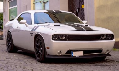 Polonya Ostrowiec Swietokrzyski 29 Mayıs 2025: 33. Dodge Challenger - Polonya caddesindeki Amerikan Pony Car, kaldırım taşı sokağına park edilmiş siyah yarış çizgileri var. Arabanın kaslı bir yapısı, büyük siyah alaşımlı tekerlekleri ve ön ızgarası var. .
