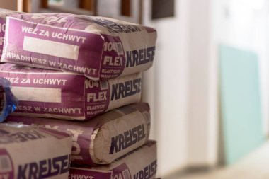 Polonya Ostrowiec Swietokrzyski 30 Mayıs 2025: 49 Kreisel yapıştırıcı paketleri üst üste istiflenmiştir. Çantalar öncelikle mor aksanlı ve özgün metinlerle bej renginde. Buna 