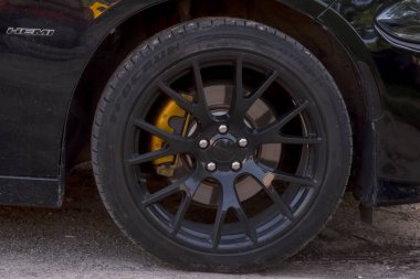 Polonya Ostrowiec Swietokrzyski 4 Temmuz 2025: 16. Amerikan kaslı arabası HEMI motorlu DODGE CHARGER belirgin bir şekilde gösterilen bir rozet, güçlü bir motor olduğunu gösteriyor. Odak noktası, birden fazla teli olan büyük bir alaşım tekerleği. .