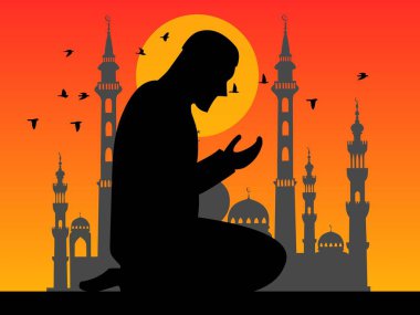 Günbatımında arka planda bir caminin silueti ve uçan kuşlarla ibadet eden ve dua eden Müslüman bir adamın silueti.